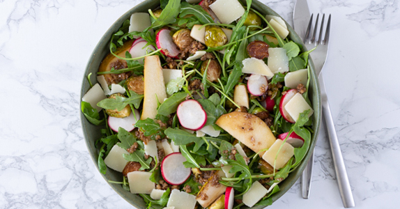 Salade met spruiten en peer op een bord geserveerd 